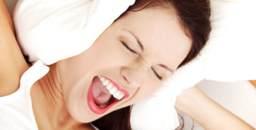 vrouw hoort hoge piep in oor is geïrriteerd